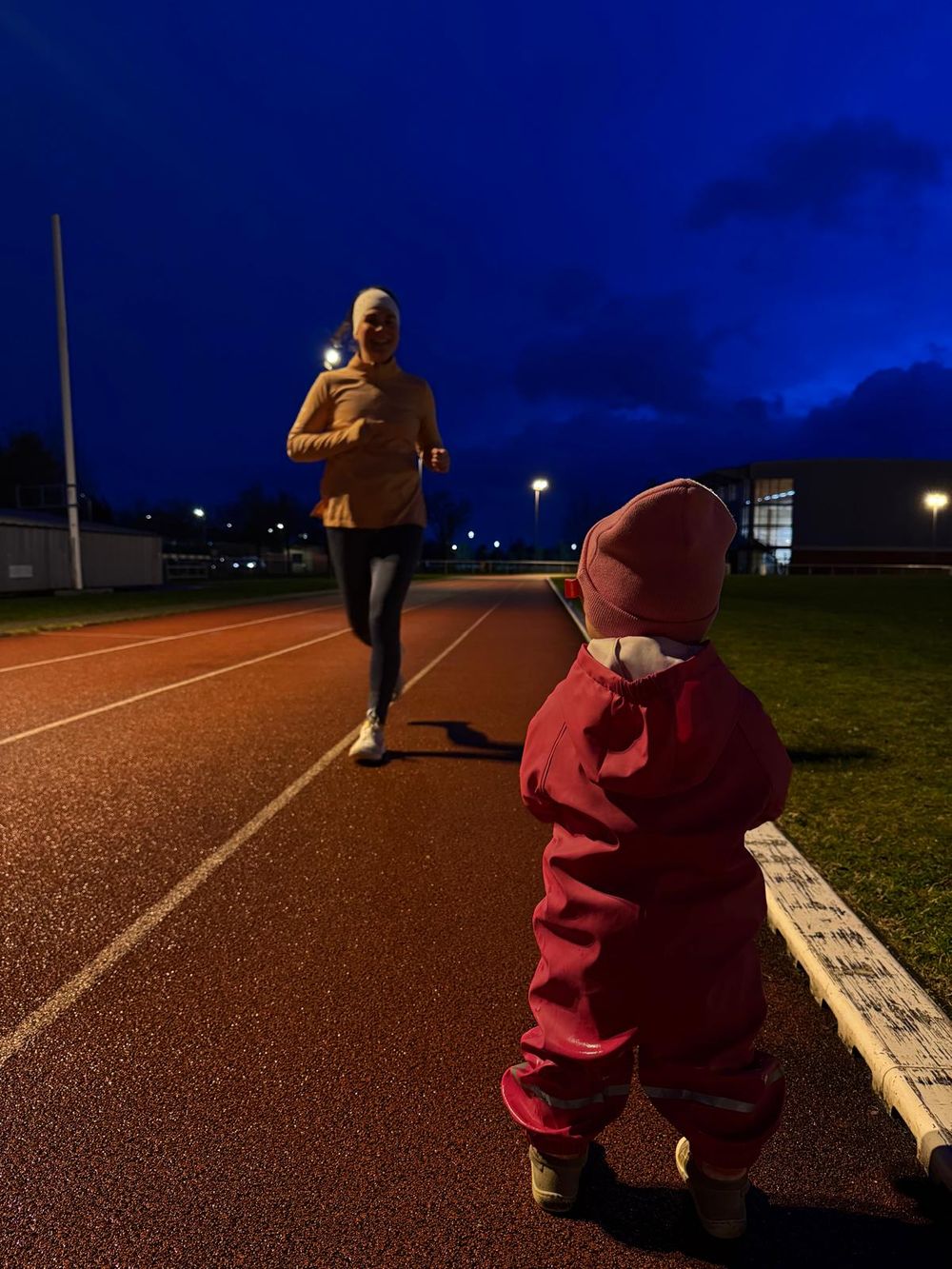 Séance de piste à la tombée de la nuit, un enfant attend au bord de la piste